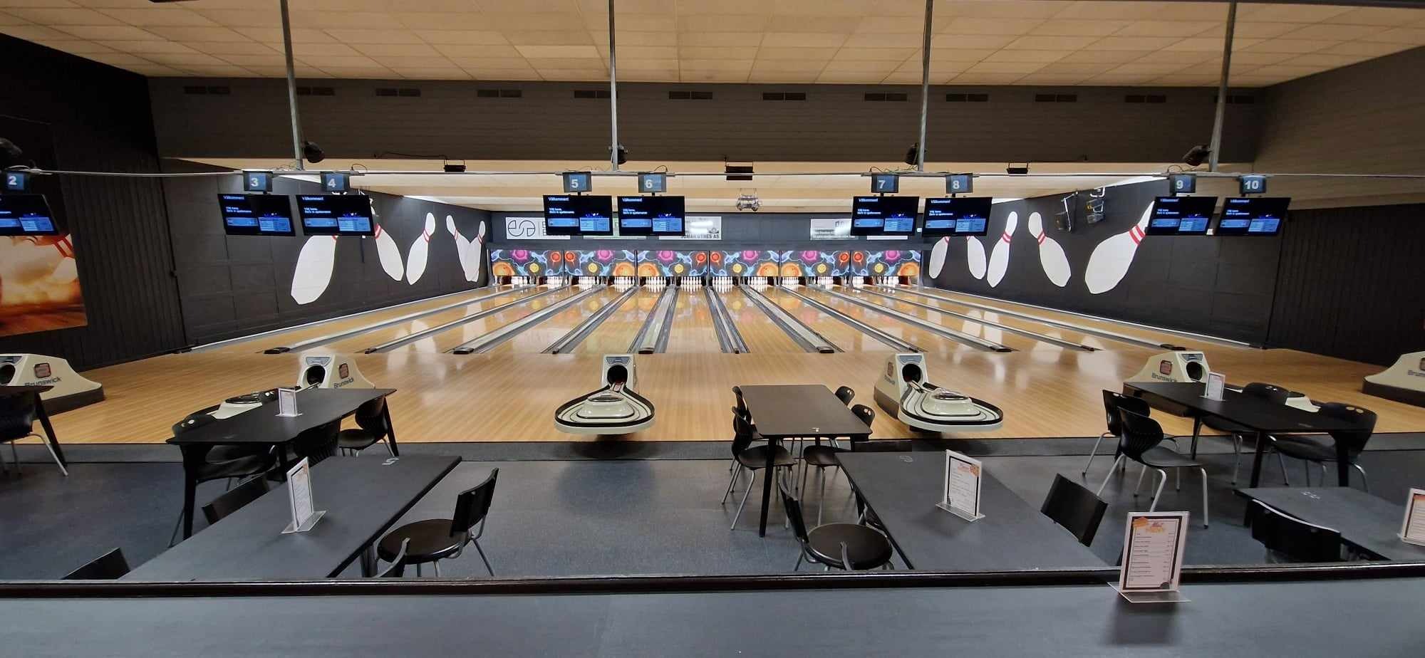 Oversiktsbilde av Dora 1 bowlinghall — 12 baner med digitale scoreskjermer, barbord i forgrunnen